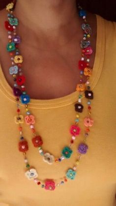 a woman wearing a yellow shirt and multicolored beaded necklace