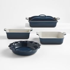 four blue and white dishes on a white surface with one bowl, the other dish