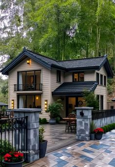 a house that is sitting in the middle of a yard with flowers and trees around it