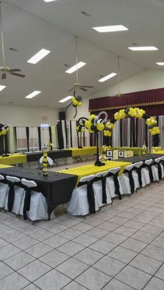 a banquet hall decorated with black and yellow decorations