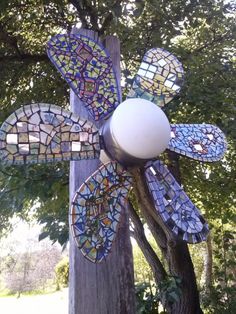 a close up of a metal object on a pole with trees in the back ground