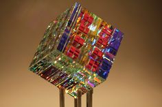 a multicolored glass sculpture sitting on top of a metal pole