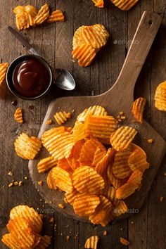 potato chips on a wooden cutting board with dipping sauce - stock photo - images in high resolution