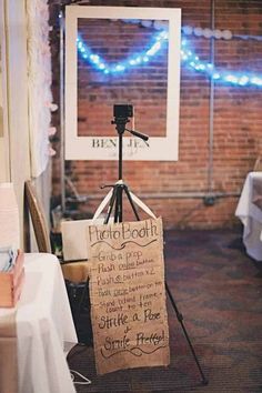 an easel with a sign attached to it sitting in front of a brick wall