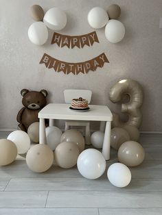 a birthday cake sitting on top of a table surrounded by balloons