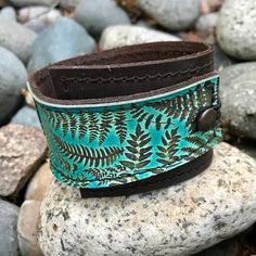 "This item is authentically handmade of genuine leather, the front has a photo digital image printed directly onto leather, produced in my studio. I've made this wrapping cuff out of soft leather, choose a black or brown base. Machine stitched, it has an attached elastic that hooks over a button, so this cuff will adjust to fit most wrist sizes 5.75\" to 7\" in circumference OR select a CUSTOM SIZE in the drop down menu. At the narrowest, the width of the cuff is 1.25\" and at the widest it's 2\ Handmade Green Leather Bracelet, Rustic Leather Bracelet With Patina For Gift, Rustic Leather Bracelet With Patina As Gift, Handmade Bohemian Leather Bracelet For Everyday, Bohemian Handmade Leather Bracelet For Everyday Use, Bohemian Handmade Leather Bracelet, Leather Bracelet For Women, Bracelet Vintage, Leather Gifts