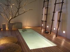 a spa room with a tree in the middle and lights on it's walls