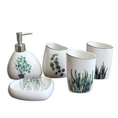 bathroom accessories including soap dispenser, toothbrush holder and cup with plants painted on them