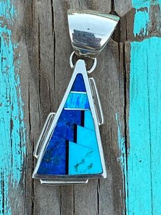 This beautifully well crafted Triangle Pendant has been handmade by a Navajo Artisan. The Colors of the Pendant come from Lapis Lazuli, Turquoise and Blue Opal. The Pendant measures 1.5 long and 5/8 wide. Winds of Wisdom (Lapis Lazuli, Turquoise and Blue Opal. The Navajo (Dine) believe that the wind is a powerful source. The native tradition believes that at any moment, the blowing wind can inspire one with hope, resolve, and great wisdom. Wisdom has long been represented by the enchanting stone Inlay Jewelry, Triangle Pendant, American Jewelry, Native American Jewelry, Blue Opal, Turquoise Jewelry, Turquoise Blue, The Wind, Things To Buy