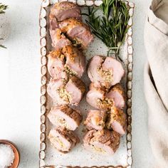 sliced pork on a plate with herbs and salt