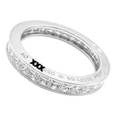 a white gold ring with diamonds on the sides and an inscription that reads x in black ink