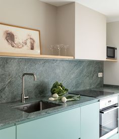 a kitchen with marble counter tops and green cabinets