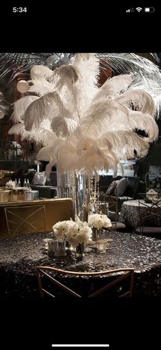 an image of a table with white flowers and feathers on it, which reads use the pinterest app if it's faster and way more fun