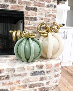 two large balloons sitting on top of a brick fireplace