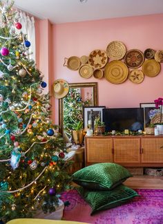 a living room with a christmas tree in the corner and plates hanging on the wall