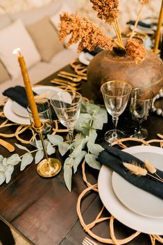 the table is set with black and gold place settings