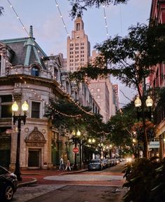 a city street filled with lots of traffic and tall buildings covered in lights at dusk