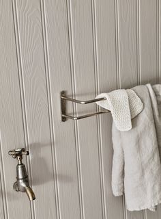 a towel hanging on the wall next to a faucet