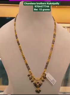 a necklace is displayed on a mannequin in front of a store display window