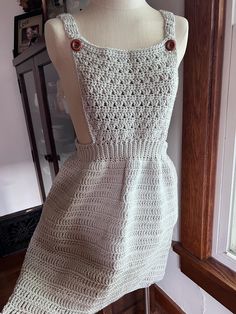 a crocheted dress is displayed on a mannequin