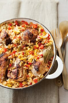 a casserole with meat and vegetables in it on a table next to silverware