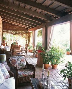 an outdoor patio with wicker furniture and potted plants