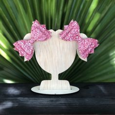 pink glitter bow headband on wooden stand