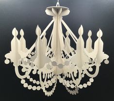 a white chandelier hanging from the ceiling with lots of cutouts on it