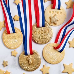 three gold medals with red, white and blue ribbons around them on a marble surface