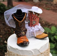 two cowboy boots are sitting on top of a wedding cake