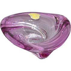 a purple glass bowl sitting on top of a white table