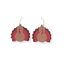 a pair of wooden earrings with a turkey design on the front and back of it