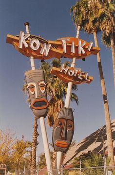 two wooden masks are attached to the sign for kon tiki hotel in palm springs, florida