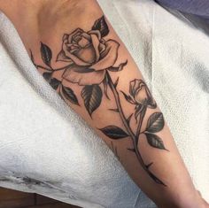 a black and white rose tattoo on the arm