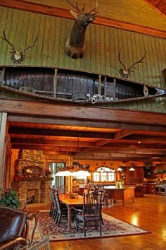 an open living room and dining area with deer heads mounted on the wall above it