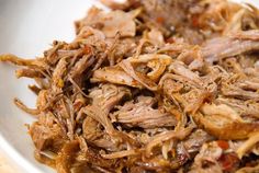 shredded meat is sitting on a white plate