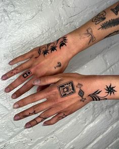 two hands with different tattoos on them