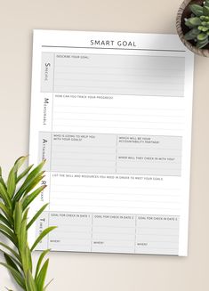 a smart goal sheet next to a potted plant