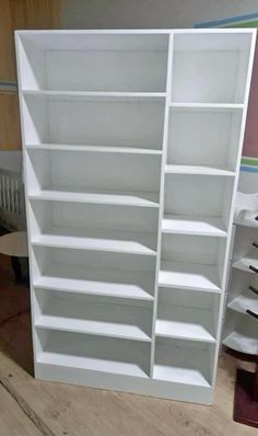 a white bookcase sitting on top of a hard wood floor