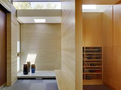 a room with wooden walls and shelves filled with vases next to windows on the wall