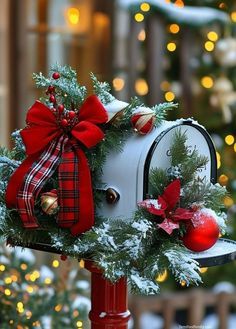 a decorated mailbox in front of a christmas tree with lights and decorations on it