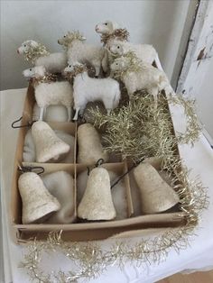 a box filled with different types of christmas decorations on top of a white table cloth