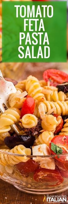 pasta salad with tomatoes, olives and cheese in a glass bowl