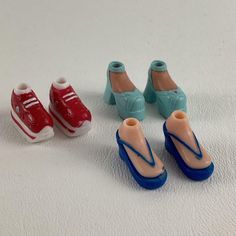 three plastic shoes and one rubber shoe are sitting on the white surface next to each other