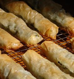 some food is cooking on a grill and it looks like they are wrapped in plastic