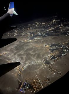 the wing of an airplane flying over a city at night