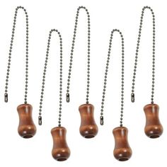 six wooden bell necklaces hanging from a ball chain on a white background with clippings