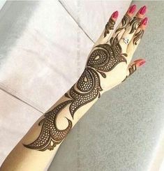 a woman's hand with henna tattoos on it