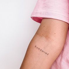 a woman's arm with the word sunshine tattooed on her left arm, in black ink