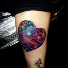 a woman's leg with a heart shaped tattoo on it and stars in the background